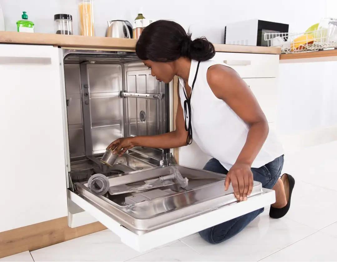 Woman cleaning out a dishwasher.