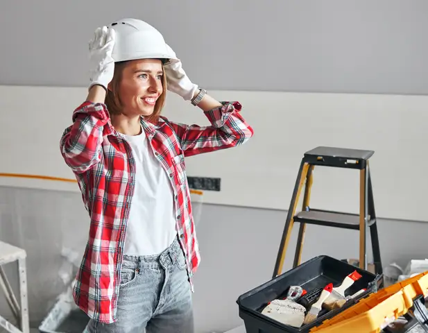 A homeowner, wearing a safety helmet, prepared to do some DIY projects.