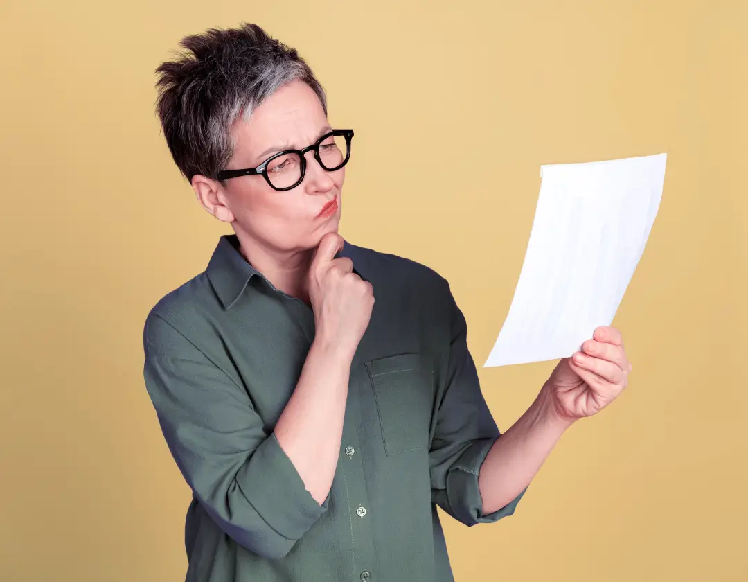A woman looking at a document, curious about it.