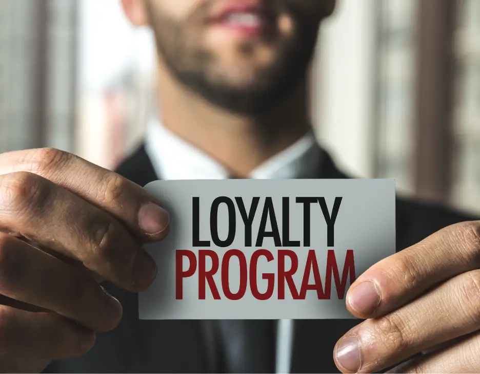 Man holding up a card that says "Loyalty Program."