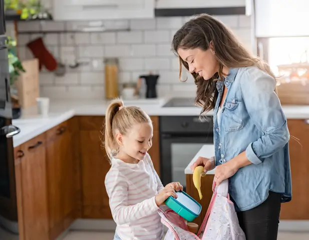 A mother and daughter gathering back-to-school materials in their home.