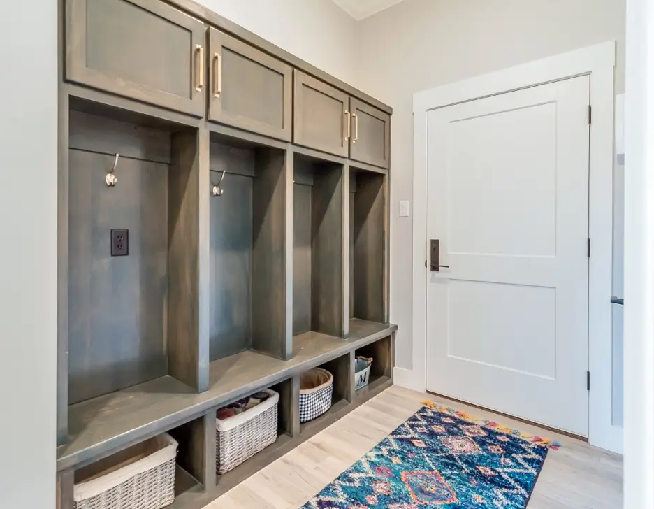 An interior look at a mudroom, with cabinets and coat rack.