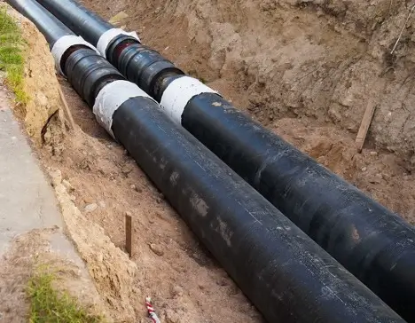 Sewer line that has been dug up through the dirt.