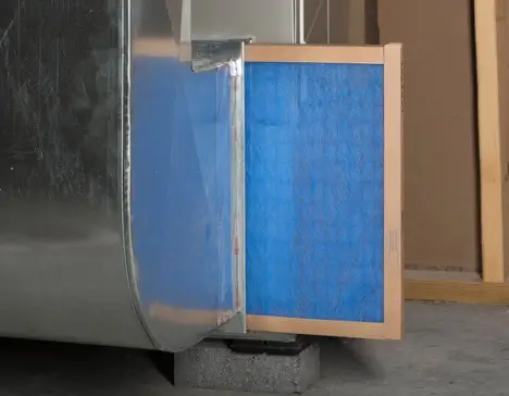 A furnace filter pulled out of the furnace for replacement.