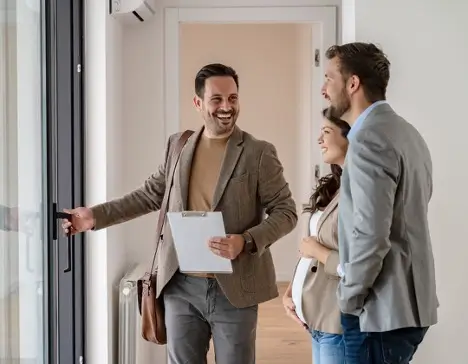 A real estate agent meeting with homeowners in an office.