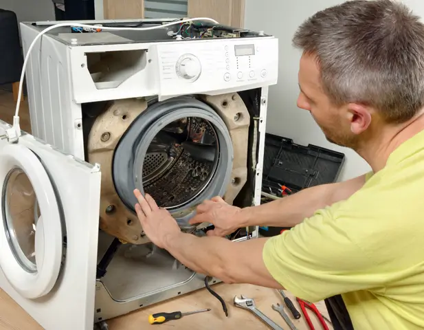 A man taking apart a washing machine.