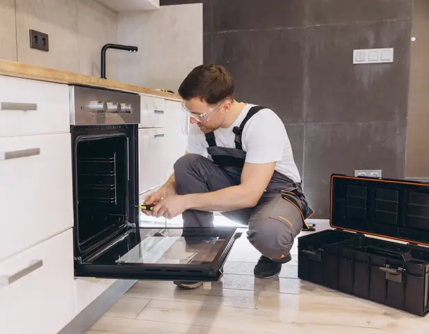 A contractor repairing a stove.