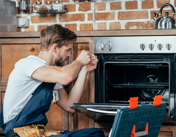 A contractor repairing an oven.