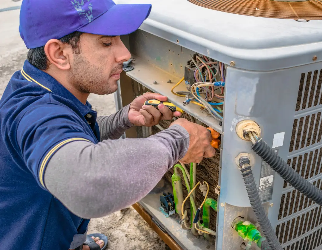 A repair man fixing the outdoor unit.