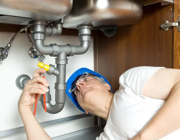 A man inspecting a plumbing system.