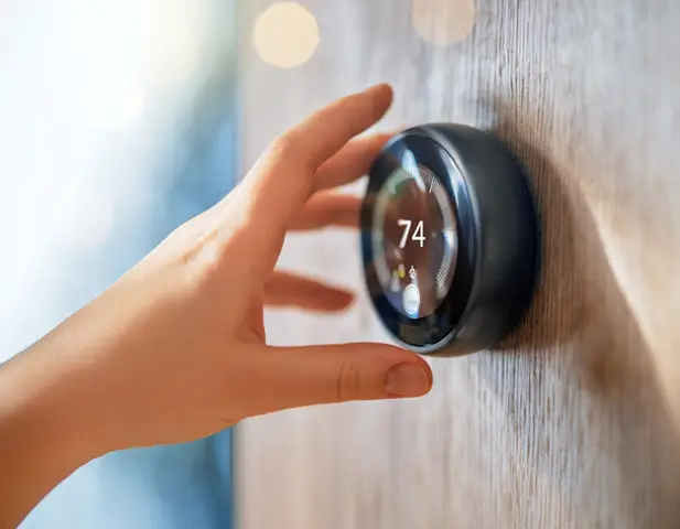 A homeowner adjusting the thermostat, testing their heating system.